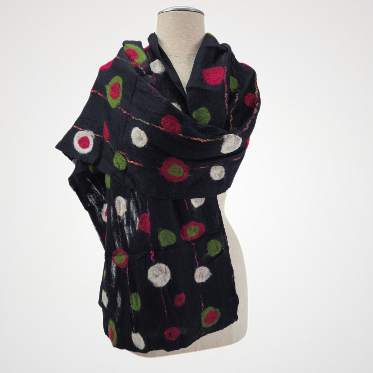 black scarf with red, green and ivory dots and fine red lines, wrapped across a mannequin's shoulders