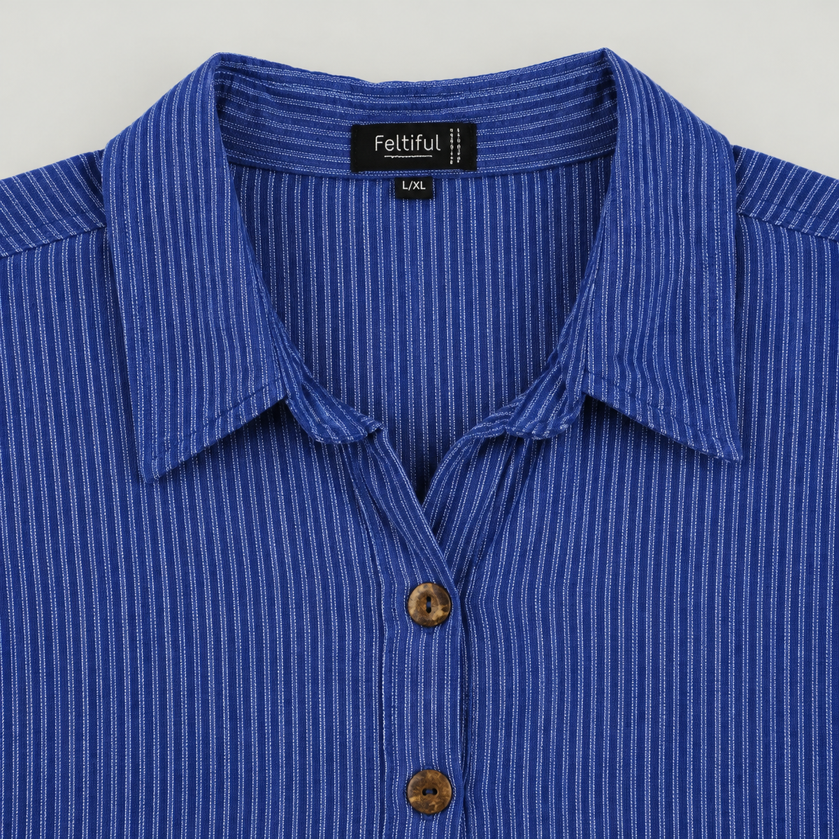 Collar and two-hole brown button detail of blue pinstripe cotton tunic