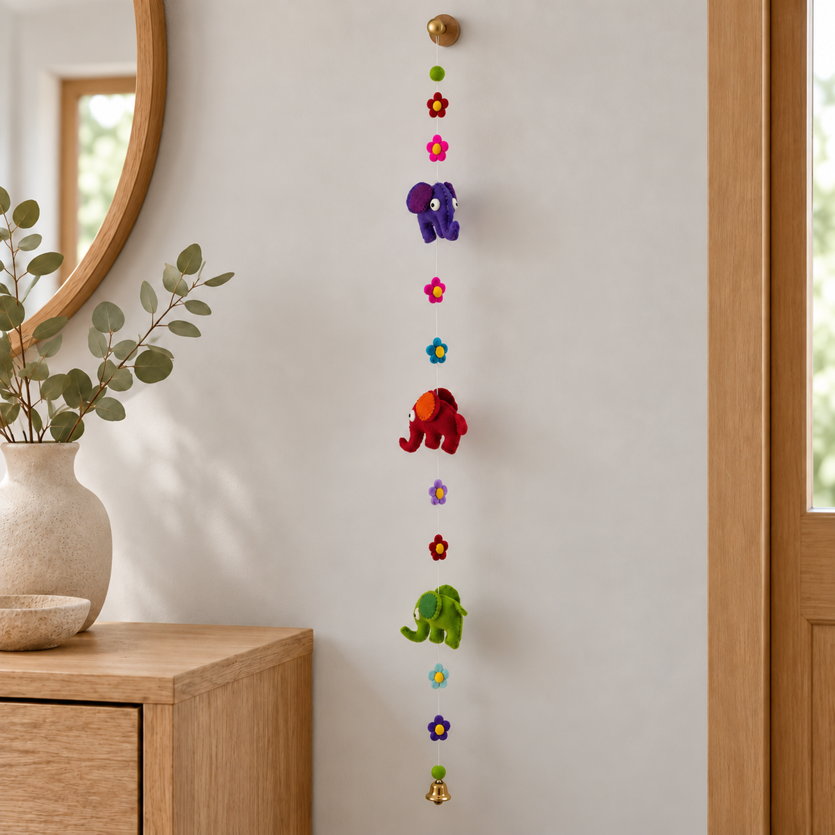 Elephant and flower hanging displayed beside an entryway console