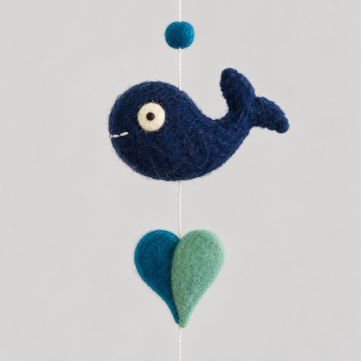 Close-up of navy wool whale and teal heart