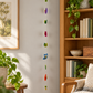 Wool owl garland displayed beside an oak bookcase