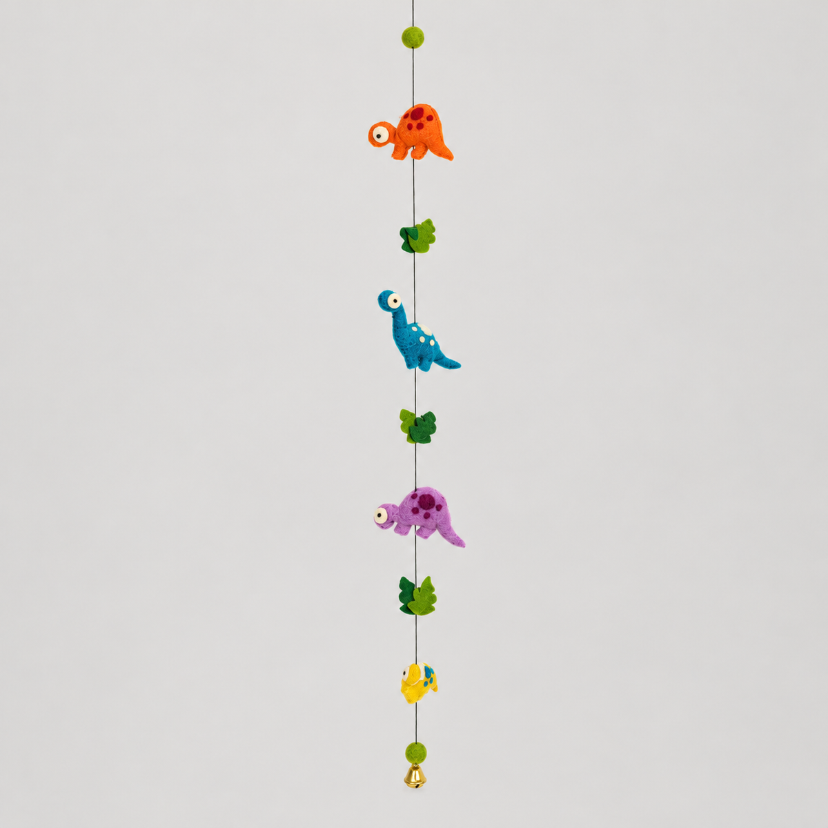 Full handmade wool dinosaur garland with green leaves and bell on warm gray