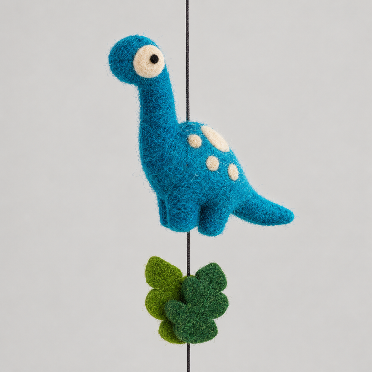 Blue long-neck wool dinosaur with cream spots and green leaves detail