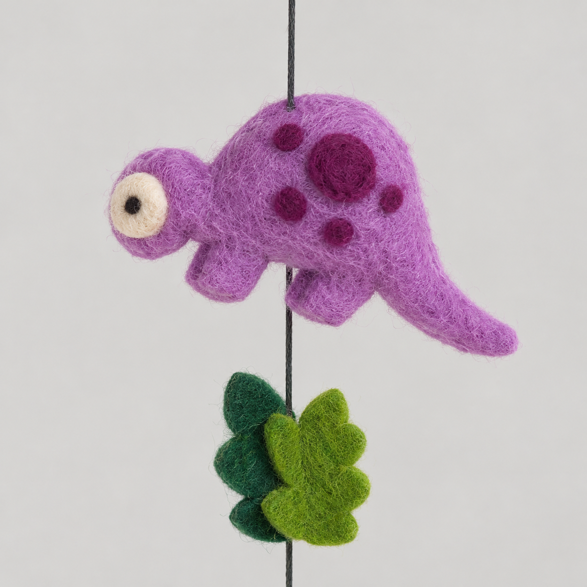 Purple wool dinosaur with plum spots and layered green leaves detail