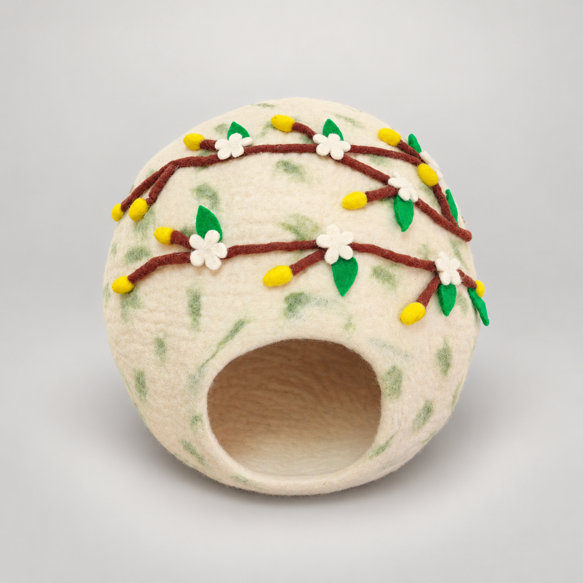 CC102 cream wool cat cave with floral felt branches on warm gray background.