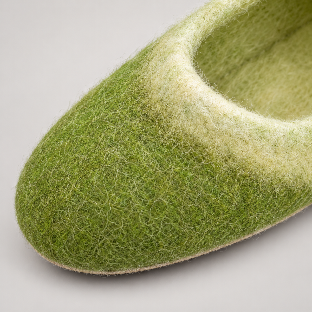 Close-up of green wool fibers and cream opening rim