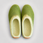 Overhead view of green and cream wool slippers with clean empty interiors
