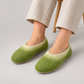 Model wearing green and cream wool felt slippers