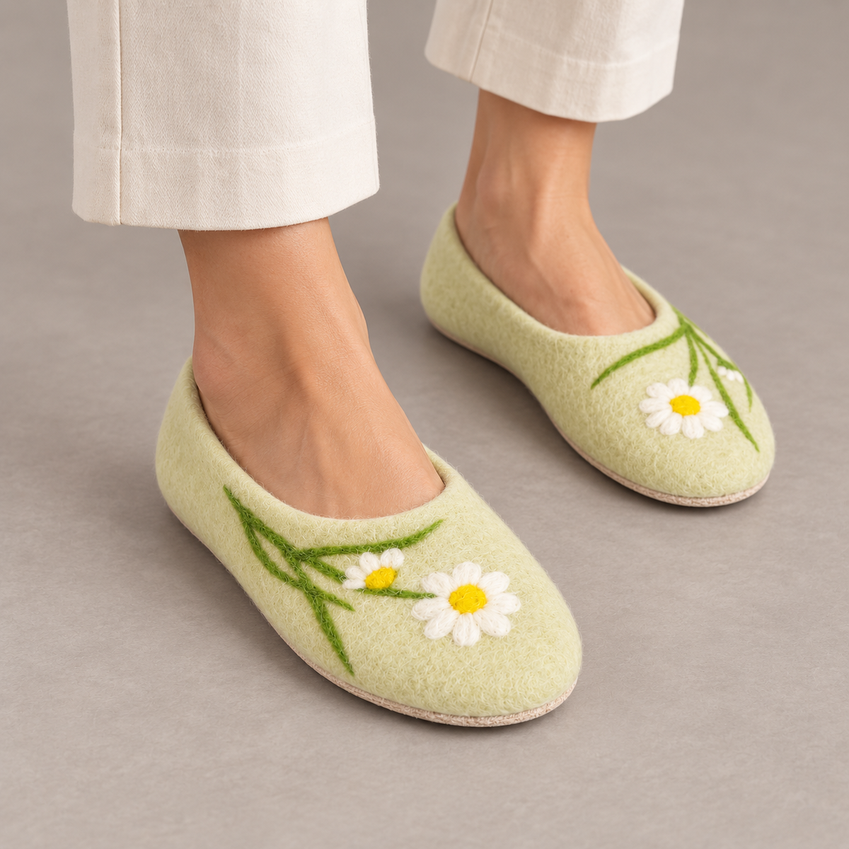 Model wearing pale green daisy wool slippers