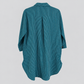 Back view of teal pinstripe cotton tunic showing center pleat and curved high-low hem, no hanger