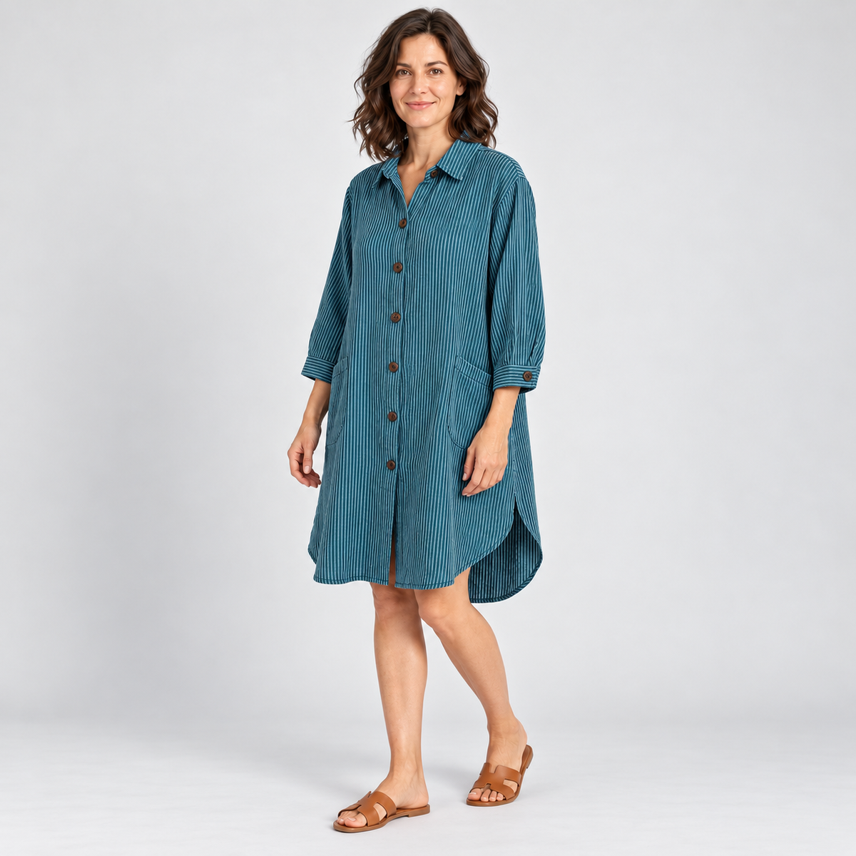 Model wearing teal pinstripe cotton high-low tunic shirt with three-quarter sleeves and pockets
