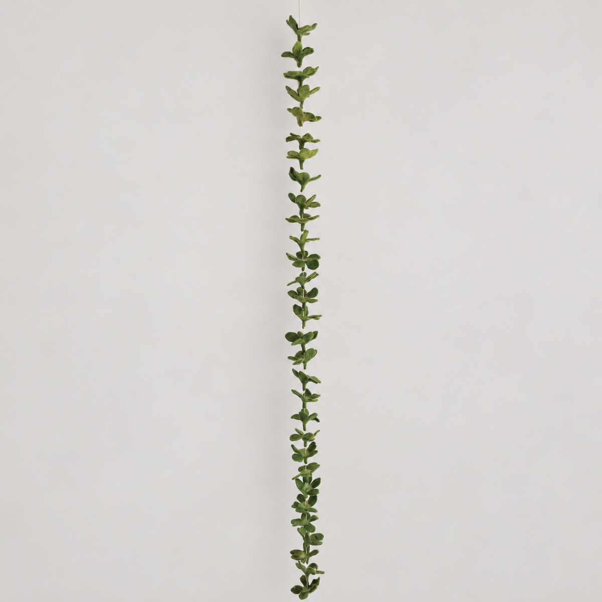 Full-length green wool leaf garland on warm gray background