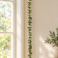 Green wool leaf garland displayed beside a window