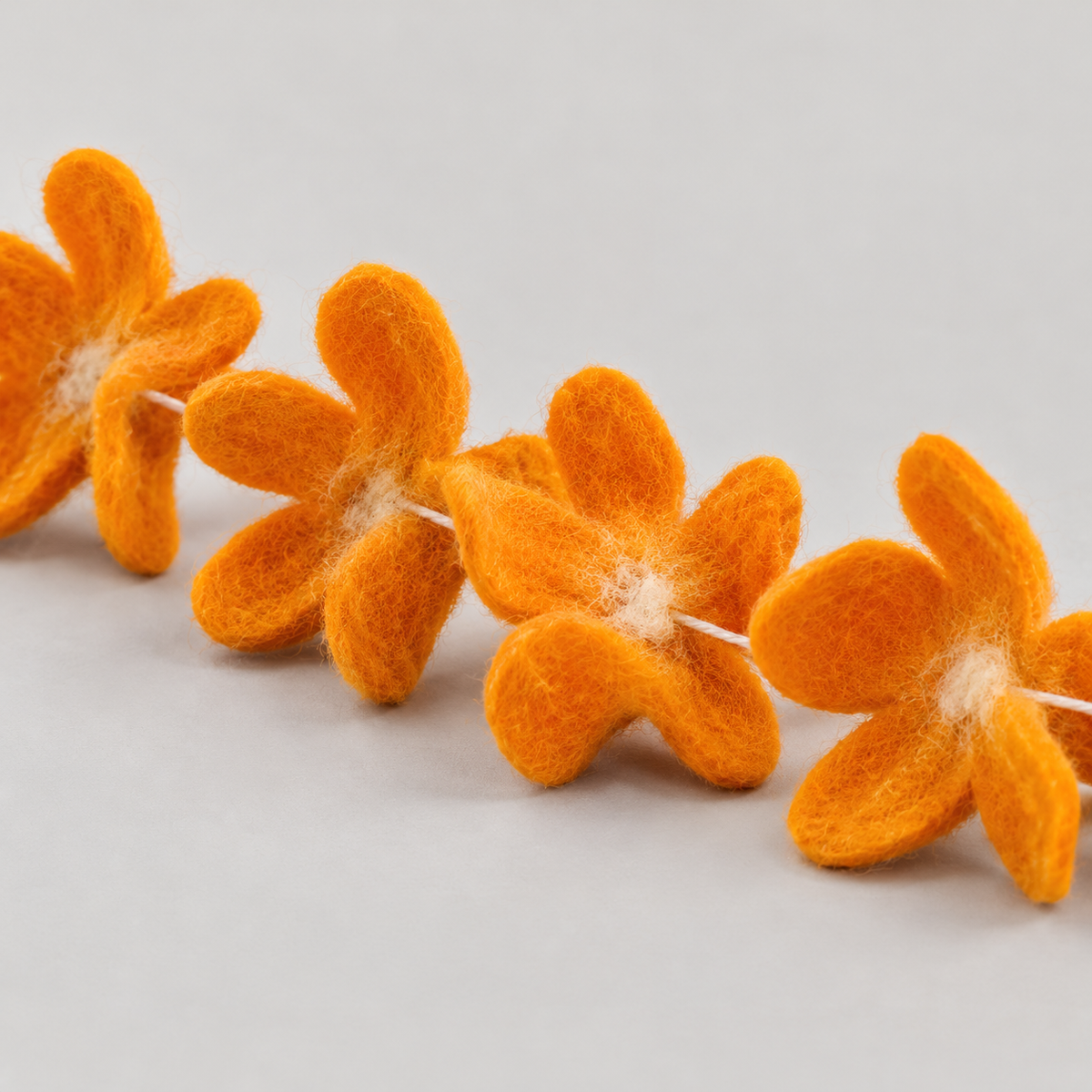 Angled detail of handmade orange felt petals