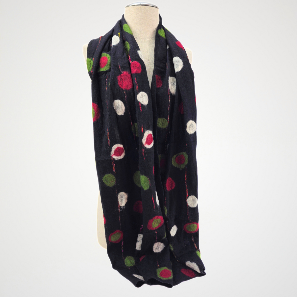 black scarf with red, green and ivory dots and fine red lines, draped on a mannequin