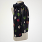 black scarf with red, green and ivory dots and fine red lines, looped around a mannequin's neck