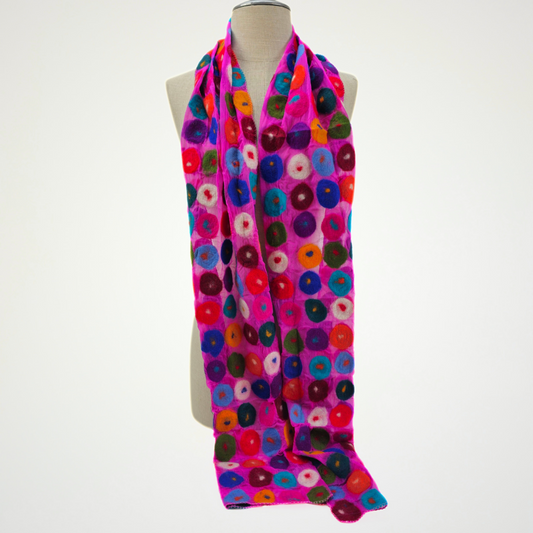 fuchsia scarf covered with multicolored circle motifs, draped on a mannequin