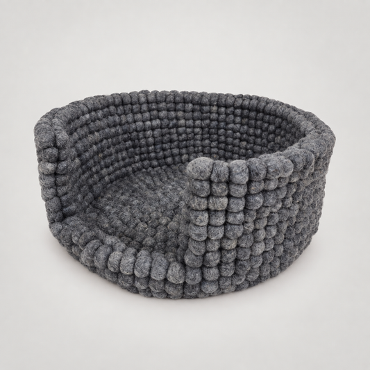 Hand Felted Po Pom Dog Bed on a soft warm gray background