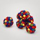 Handmade Multi Color Rattler Ball on a soft warm gray background