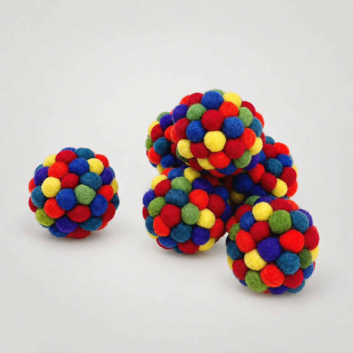 Handmade Multi Color Rattler Ball on a soft warm gray background