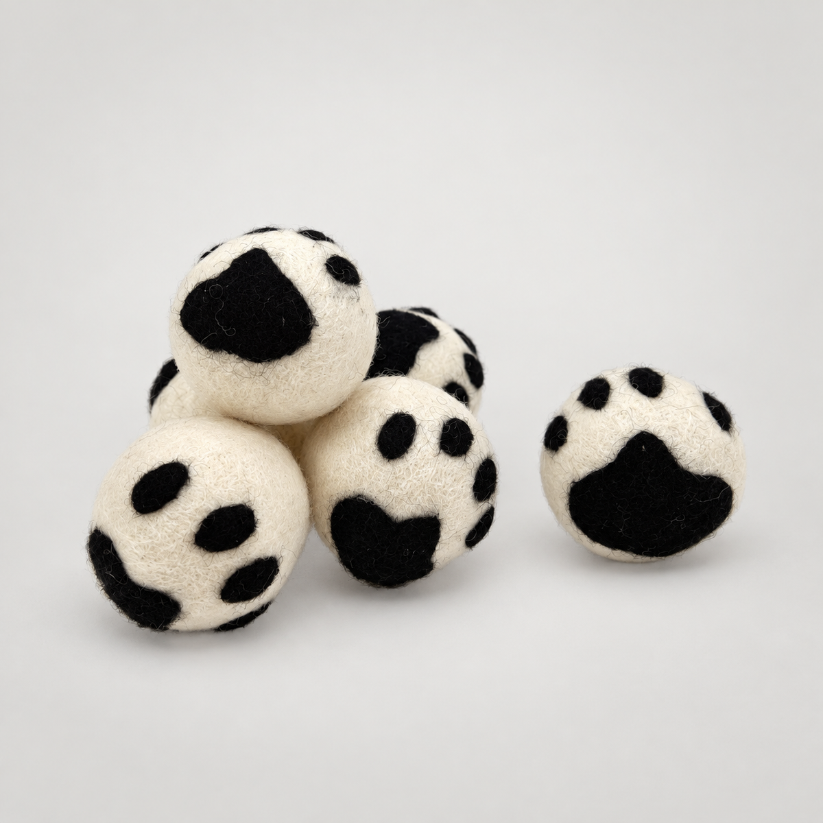 Handmade Paw Rattler Ball on a soft warm gray background
