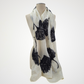 Ivory scarf with black ginkgo leaf motifs draped on a mannequin