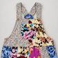Buttoned bib pocket and shoulder strap detail on patchwork cotton overalls