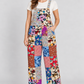 Model wearing patchwork cotton overalls with one hand in a side pocket