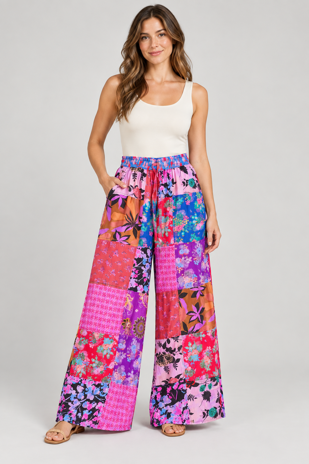 Model wearing pink patchwork cotton wide-leg trousers with one hand in a pocket