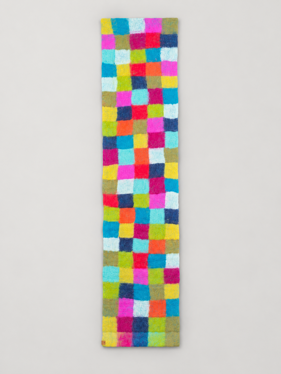 Multicolor checker felt wool table runner on warm gray background