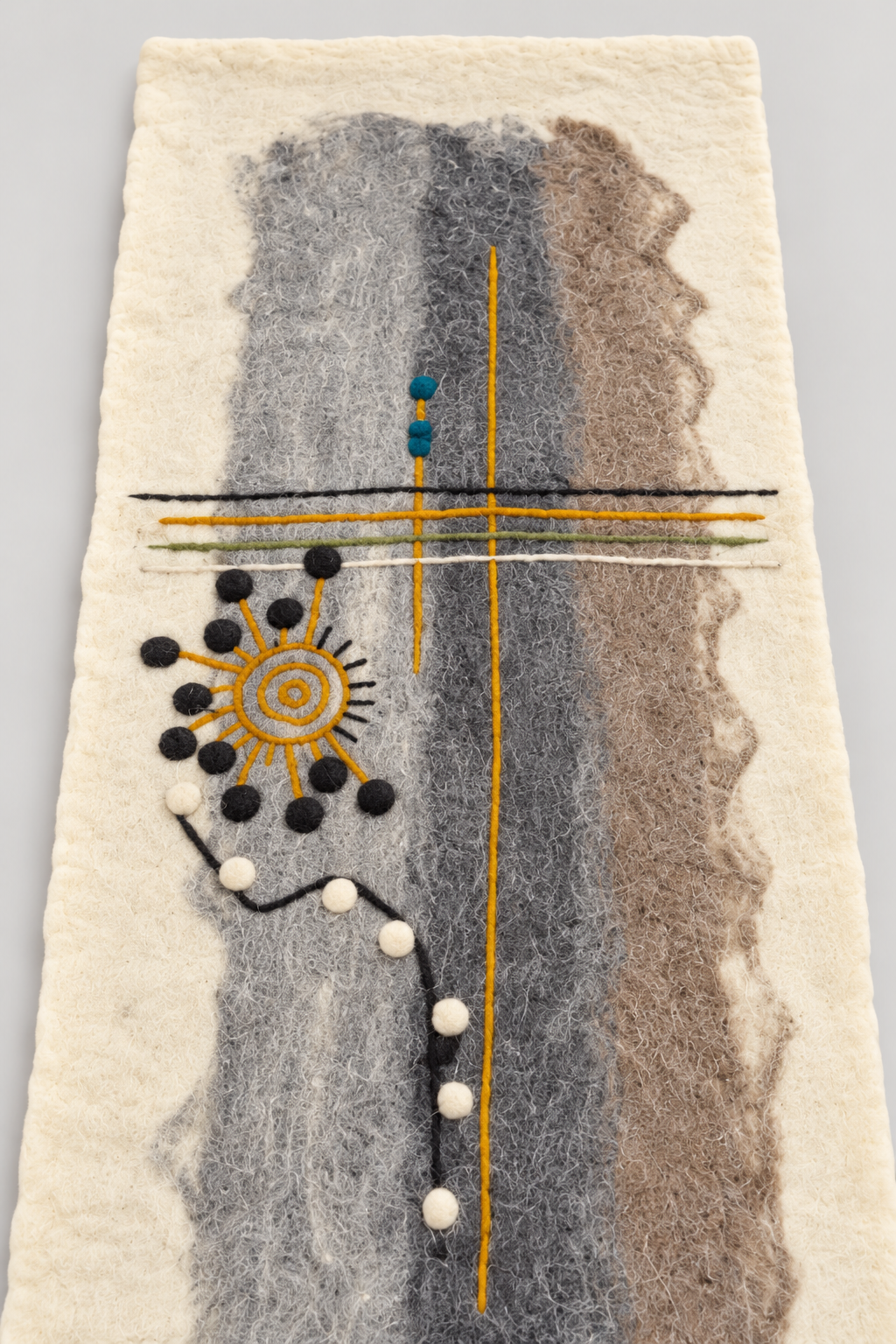 Close-up of spiral sun and line details on felt wool runner