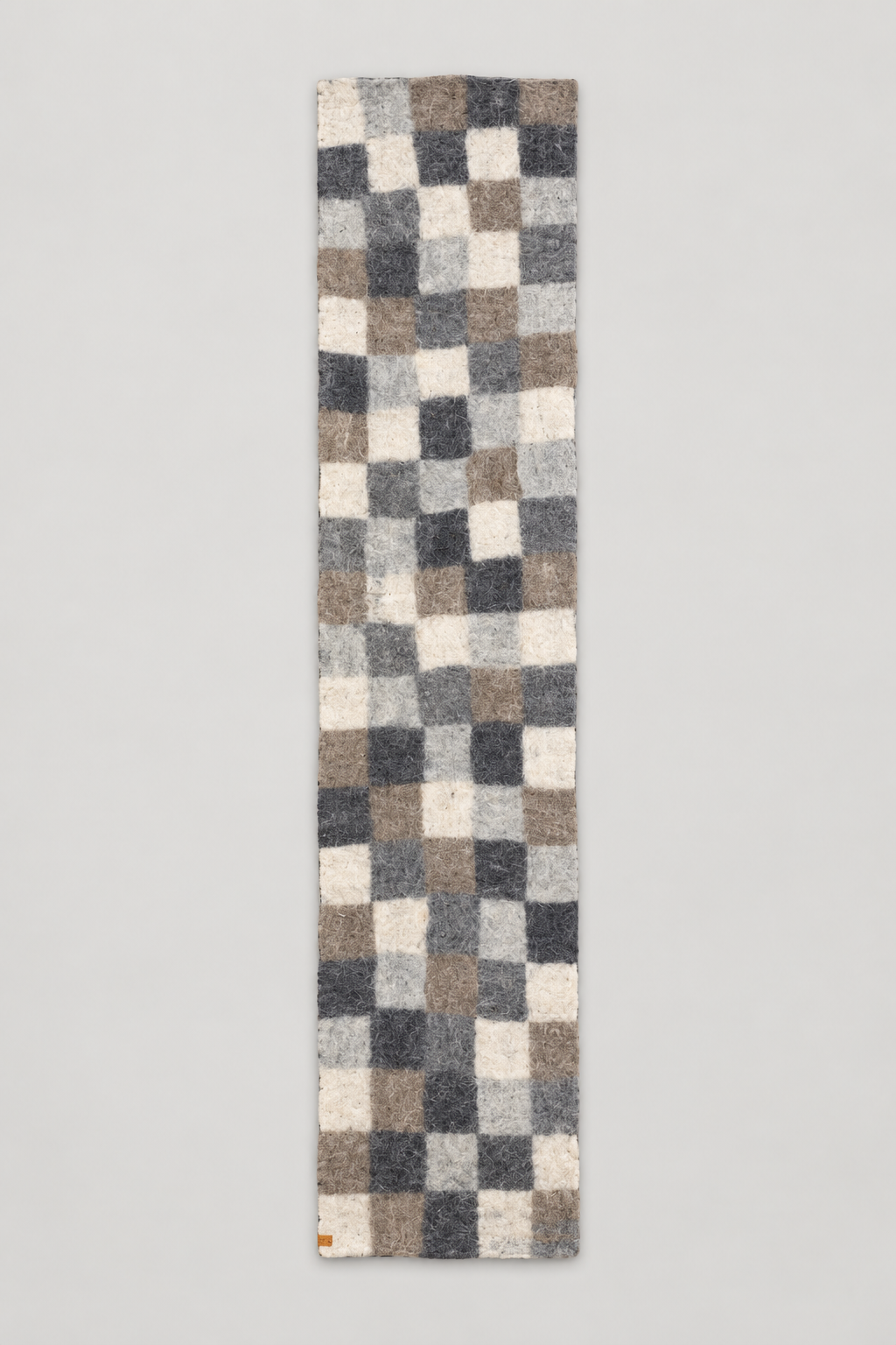Neutral checker felt wool table runner on warm gray background