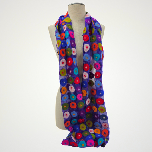 purple scarf covered with multicolored circle motifs, draped on a mannequin