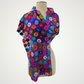 purple scarf covered with multicolored circle motifs, wrapped across a mannequin's shoulders