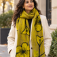 Woman wearing Feltiful hand-felted mustard yellow, taupe and black floral merino wool and silk scarf